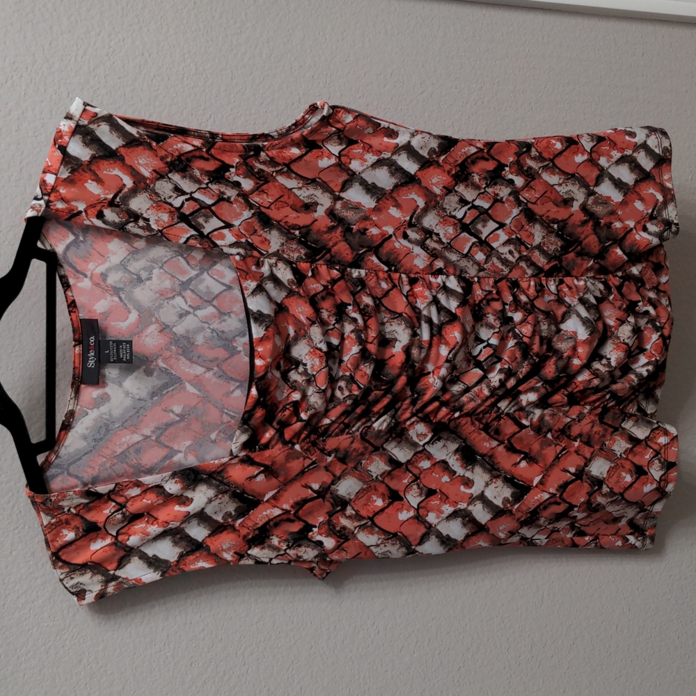 Geometric shell blouse with cut off sleeve.